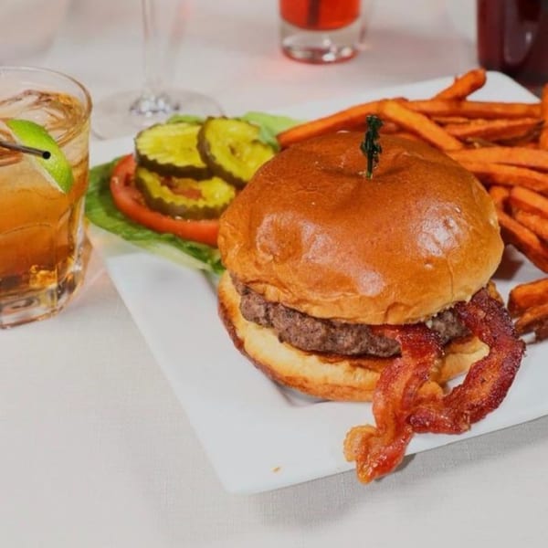Prime 7 Bar & Restaurant's bacon cheeseburger with sweet potato fries, pickles, and a cocktail.
